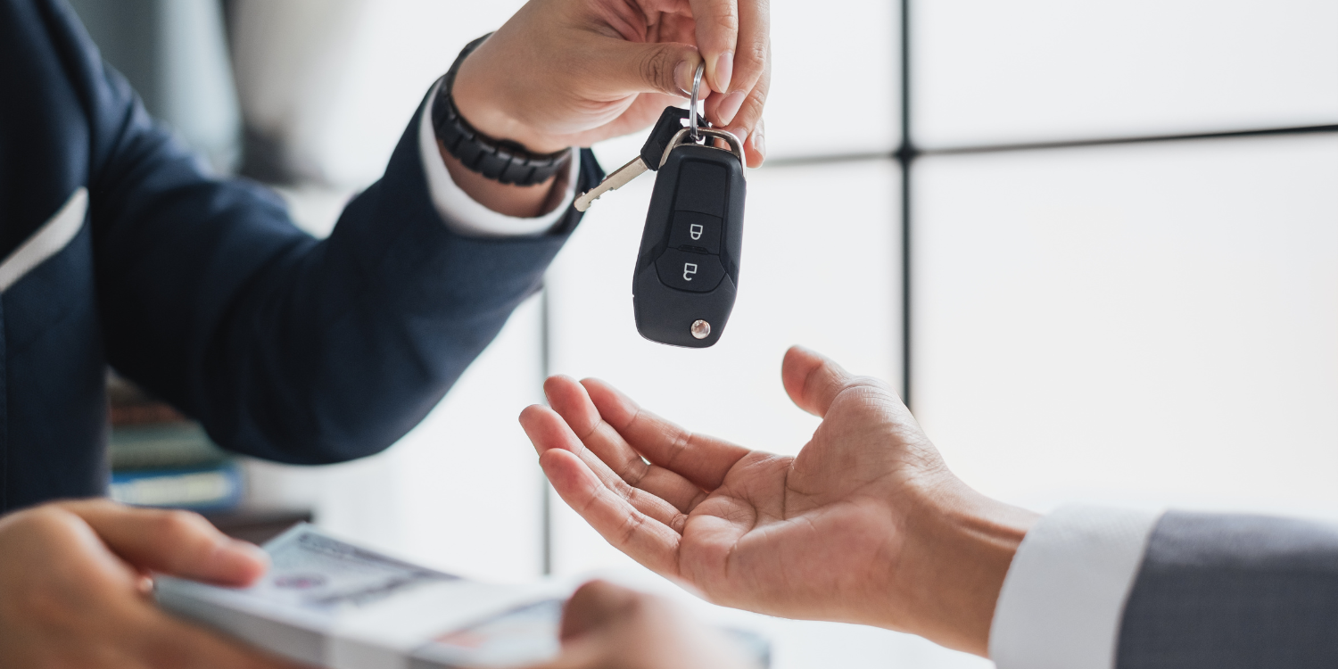 Dando la llave de un coche al cliente